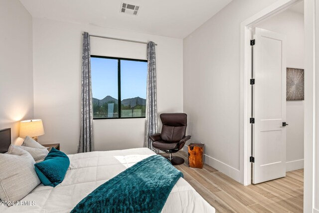 bedroom featuring hardwood / wood-style floors and a mountain view