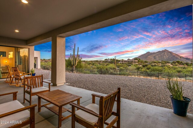 patio terrace at dusk featuring a mountain view