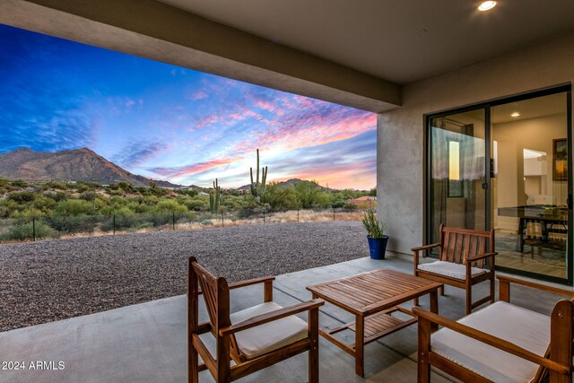 patio terrace at dusk featuring a mountain view