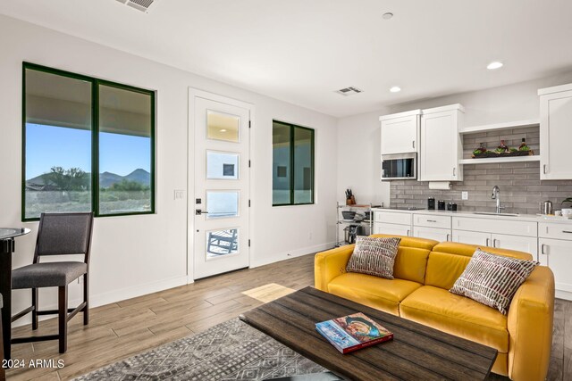 living room with sink and light wood-type flooring