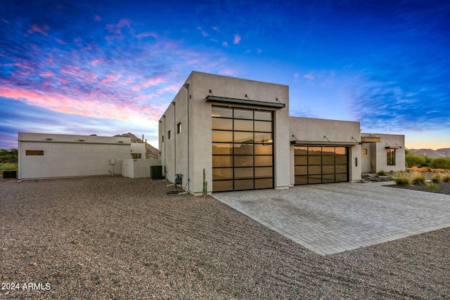 view of front of property featuring a garage and cooling unit