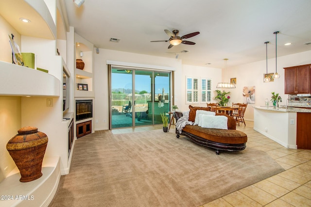 sitting room with light tile patterned floors and ceiling fan