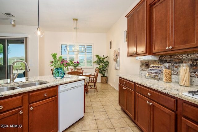 kitchen featuring pendant lighting, dishwasher, sink, light stone countertops, and a healthy amount of sunlight