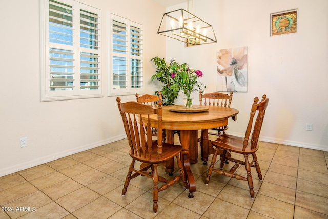 dining area featuring light tile patterned flooring and a notable chandelier