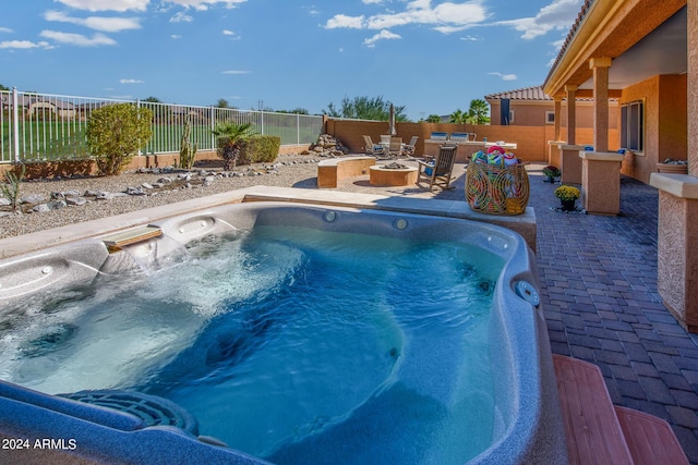 view of swimming pool with an outdoor hot tub, a patio area, and an outdoor fire pit