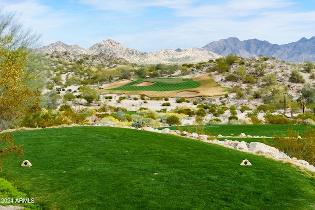 view of home's community with a mountain view and a lawn