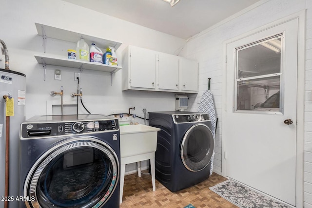 washroom featuring light parquet flooring, water heater, cabinets, and independent washer and dryer