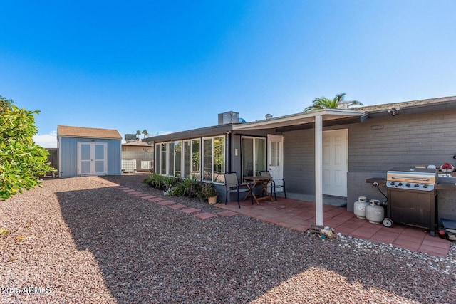 back of property with a patio and a storage shed