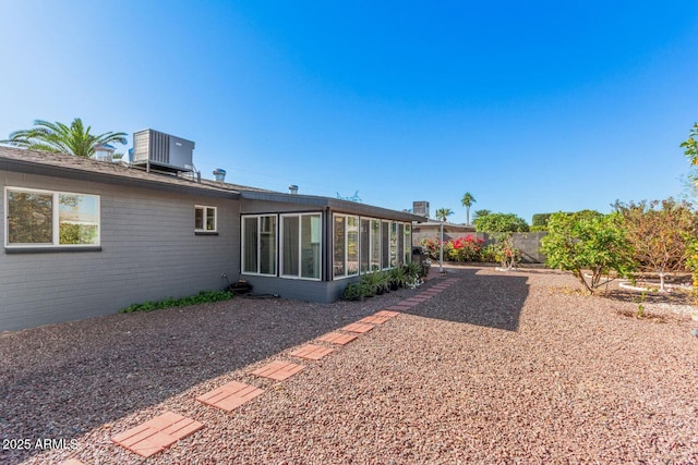 view of yard featuring a sunroom and central air condition unit