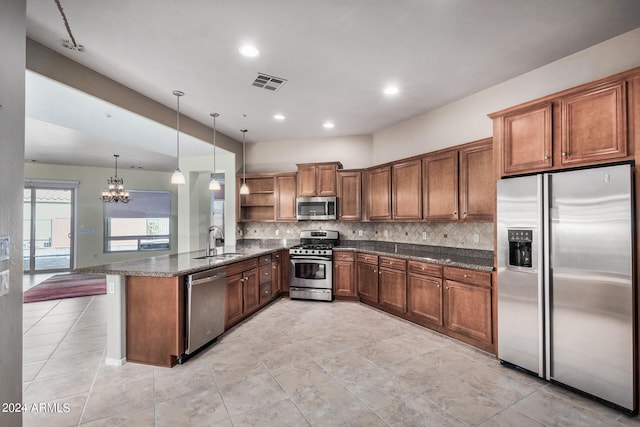 kitchen featuring hanging light fixtures, appliances with stainless steel finishes, a notable chandelier, sink, and kitchen peninsula