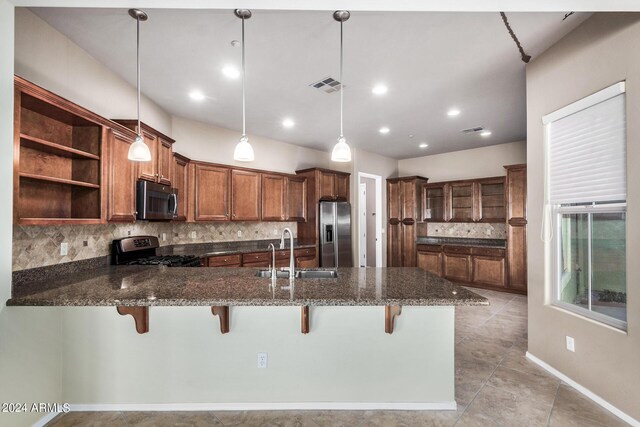 kitchen with kitchen peninsula, stainless steel appliances, sink, and hanging light fixtures