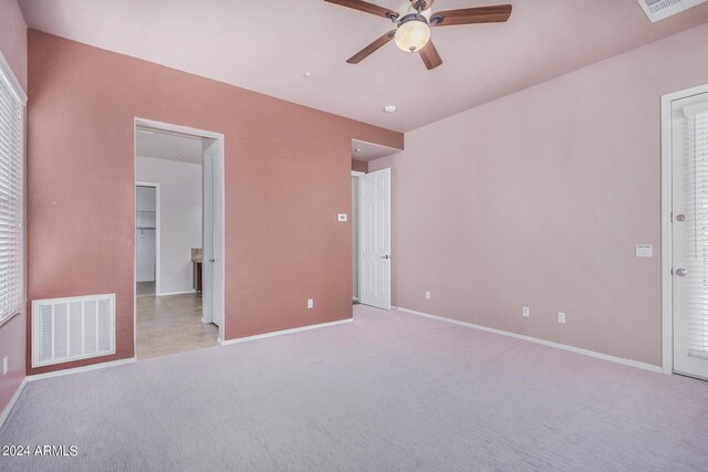 unfurnished bedroom featuring light colored carpet and ceiling fan