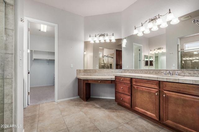 bathroom with tile patterned flooring, vanity, and walk in shower