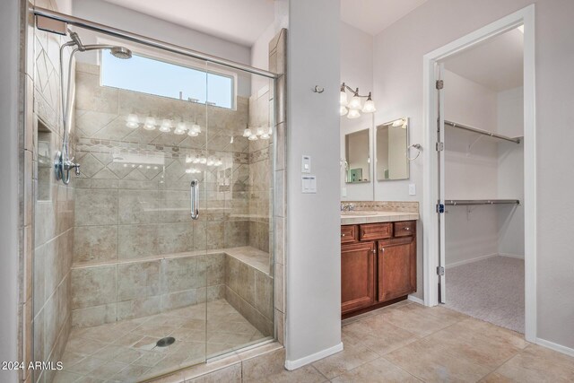 bathroom featuring tile patterned floors, an enclosed shower, and vanity