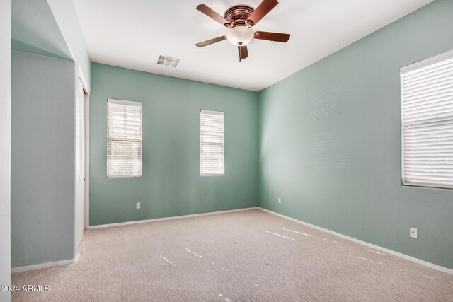 carpeted spare room featuring ceiling fan