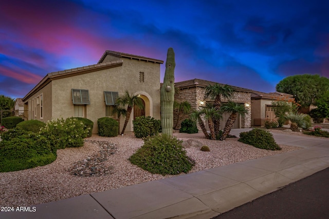 mediterranean / spanish house featuring stucco siding, concrete driveway, and an attached garage