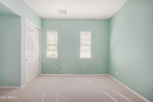 spare room featuring light carpet