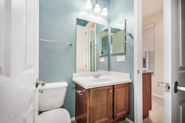 bathroom with tile patterned flooring, toilet, and vanity