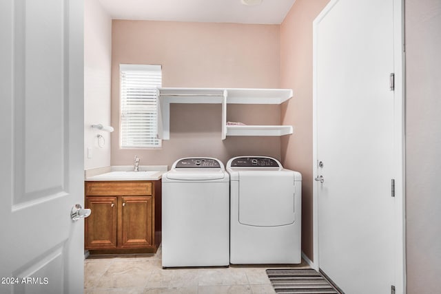 laundry room with light tile patterned floors, cabinets, sink, and separate washer and dryer