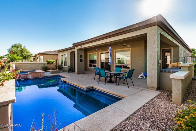 view of pool featuring an in ground hot tub, an outdoor kitchen, and a patio area