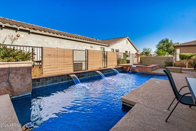 view of pool featuring a patio area, an in ground hot tub, and pool water feature