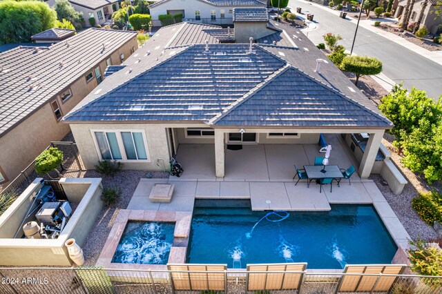 view of pool with pool water feature, a patio, and an in ground hot tub