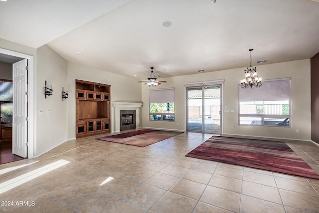 unfurnished living room featuring ceiling fan with notable chandelier and light tile patterned flooring