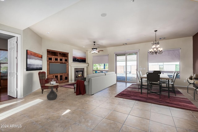 dining space featuring ceiling fan with notable chandelier, a wealth of natural light, and light tile patterned flooring