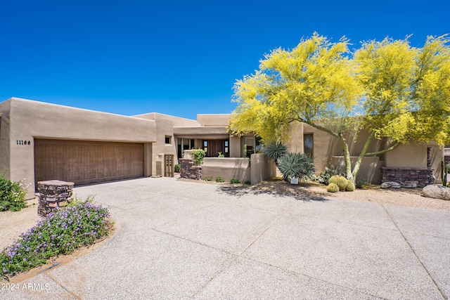 pueblo-style house featuring a garage