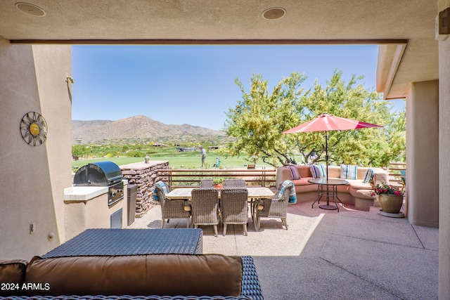 view of patio featuring a mountain view, grilling area, and exterior kitchen