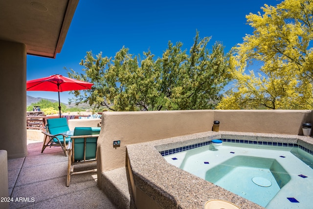 view of pool with a mountain view, a patio, and an in ground hot tub