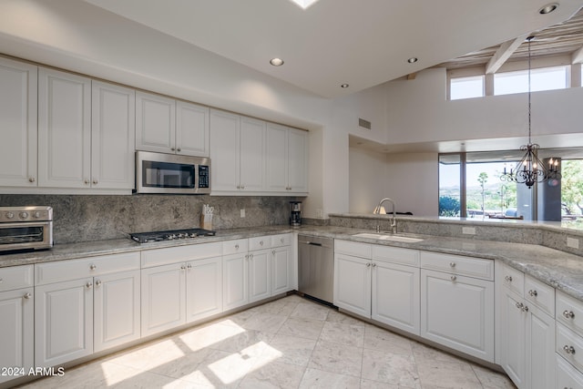 kitchen with white cabinets, appliances with stainless steel finishes, sink, and a wealth of natural light