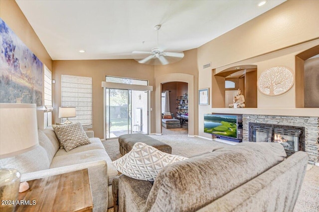 living room featuring ceiling fan, vaulted ceiling, a fireplace, and carpet floors