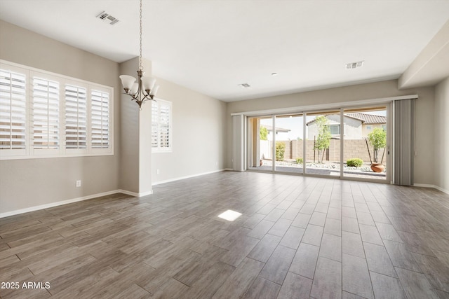 20473 W Legend Trl, Buckeye, AZ 85396 - empty room featuring wood finished floors, a chandelier, and baseboards