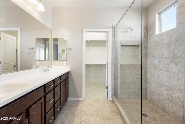 20473 W Legend Trl, Buckeye, AZ 85396 - bathroom featuring a walk in shower, double vanity, tile patterned flooring, and baseboards