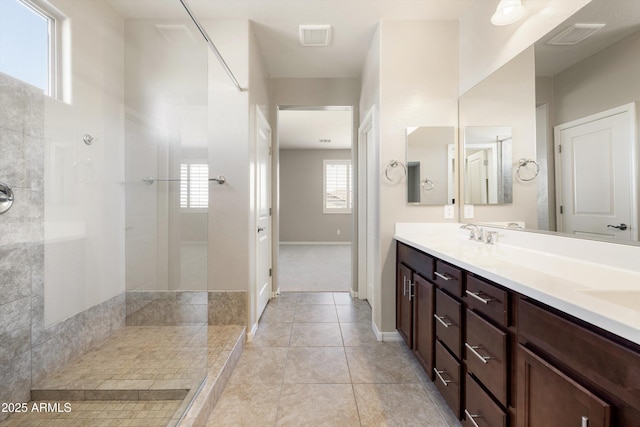 20473 W Legend Trl, Buckeye, AZ 85396 - bathroom featuring double vanity, walk in shower, tile patterned flooring, and baseboards