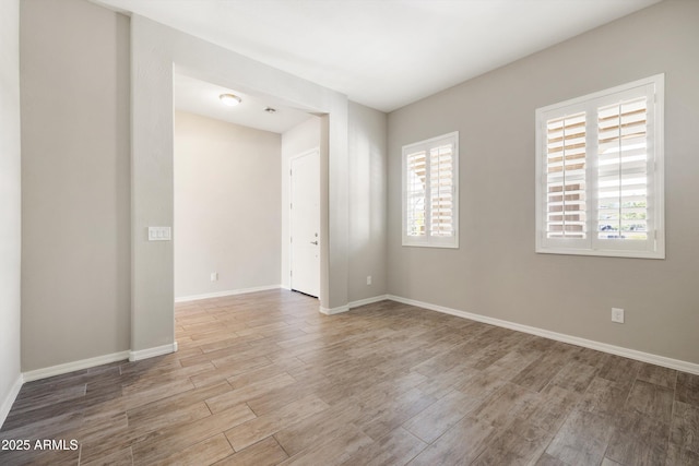 20473 W Legend Trl, Buckeye, AZ 85396 - empty room featuring plenty of natural light, wood finished floors, and baseboards