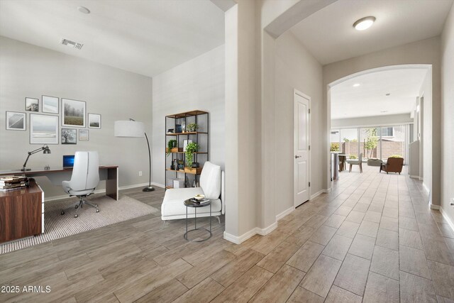 20473 W Legend Trl, Buckeye, AZ 85396 - office area featuring arched walkways, wood finished floors, and baseboards