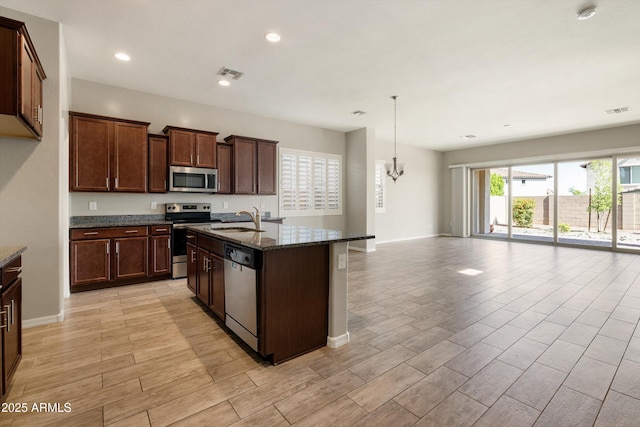 20473 W Legend Trl, Buckeye, AZ 85396 - kitchen with stainless steel appliances, a sink, light wood-style flooring, open floor plan, and recessed lighting
