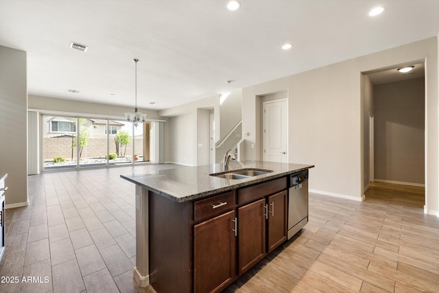 20473 W Legend Trl, Buckeye, AZ 85396 - kitchen featuring a sink, dishwasher, dark stone counters, light wood-type flooring, and baseboards