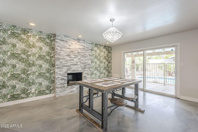 5330 E Tierra Buena Ln, Scottsdale, AZ 85254 - dining space featuring baseboards, wallpapered walls, finished concrete flooring, a chandelier, and a fireplace