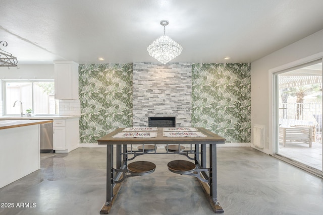 5330 E Tierra Buena Ln, Scottsdale, AZ 85254 - dining area with wallpapered walls, concrete floors, baseboards, and a chandelier