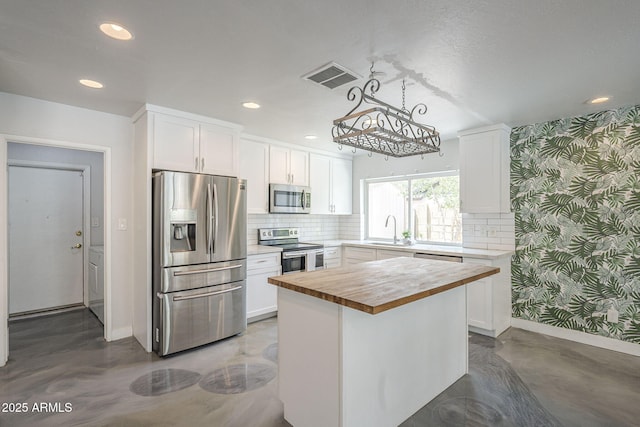 5330 E Tierra Buena Ln, Scottsdale, AZ 85254 - kitchen with stainless steel appliances, wood counters, wallpapered walls, baseboards, and white cabinets