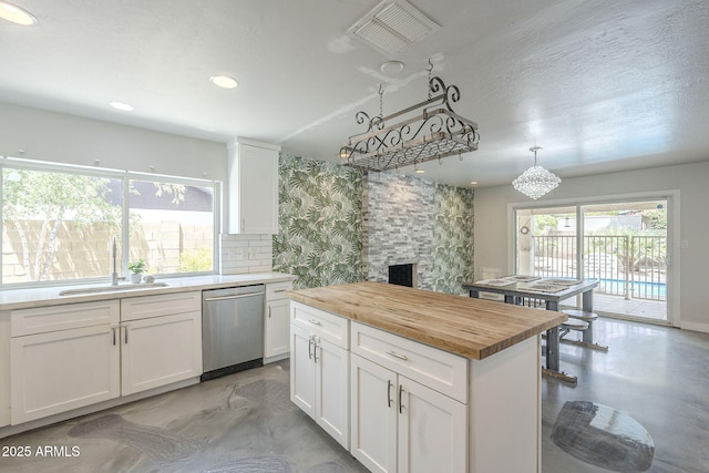 5330 E Tierra Buena Ln, Scottsdale, AZ 85254 - kitchen featuring dishwasher, wooden counters, a sink, a fireplace, and white cabinetry