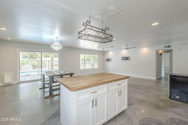 5330 E Tierra Buena Ln, Scottsdale, AZ 85254 - kitchen with wood counters, concrete flooring, white cabinets, a center island, and recessed lighting