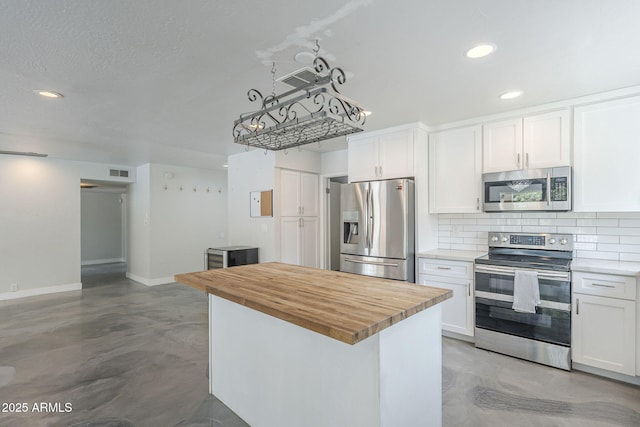5330 E Tierra Buena Ln, Scottsdale, AZ 85254 - kitchen featuring appliances with stainless steel finishes, wood counters, concrete flooring, backsplash, and white cabinetry