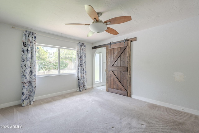 5330 E Tierra Buena Ln, Scottsdale, AZ 85254 - spare room with a barn door, a ceiling fan, carpet, and baseboards
