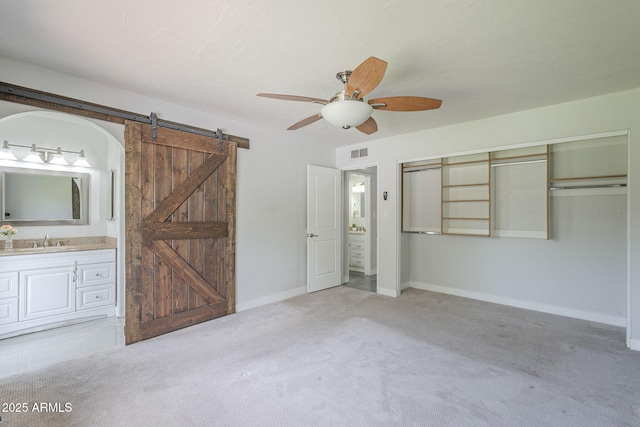 5330 E Tierra Buena Ln, Scottsdale, AZ 85254 - unfurnished bedroom featuring a barn door, a sink, carpet floors, and ensuite bathroom