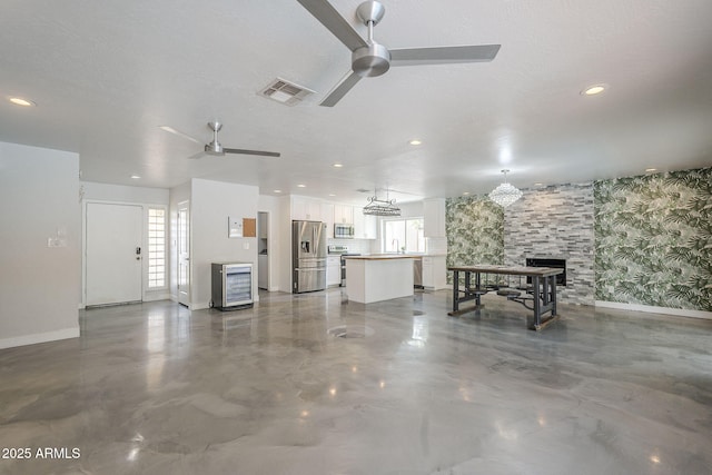 5330 E Tierra Buena Ln, Scottsdale, AZ 85254 - living area featuring ceiling fan, baseboards, wallpapered walls, a fireplace, and concrete flooring