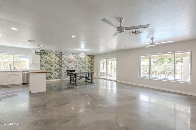 5330 E Tierra Buena Ln, Scottsdale, AZ 85254 - unfurnished living room with baseboards, ceiling fan, a stone fireplace, recessed lighting, and finished concrete floors